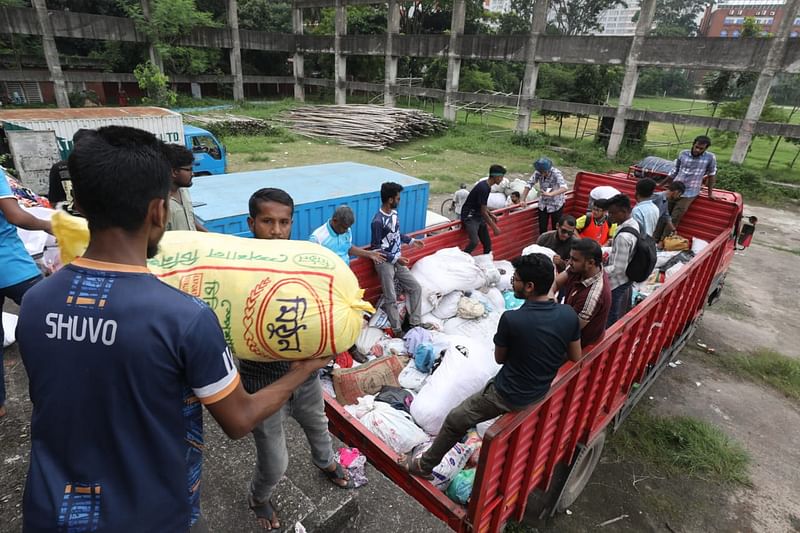 বন্যাকবলিত মানুষের জন্য বিভিন্ন স্থান থেকে আসা ত্রাণ ট্রাক থেকে নামাচ্ছেন শিক্ষার্থীরা। আজ মঙ্গলবার ঢাকা বিশ্ববিদ্যালয় সুইমিংপুলের মাঠে